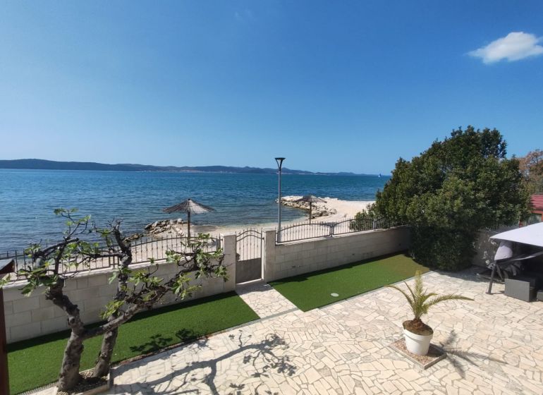 A family house in Bibinje offers a sea view with a stone terrace and garden greenery.