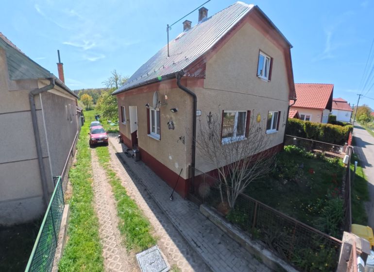 A family house in Svinná with a car on the driveway and a well-maintained garden.