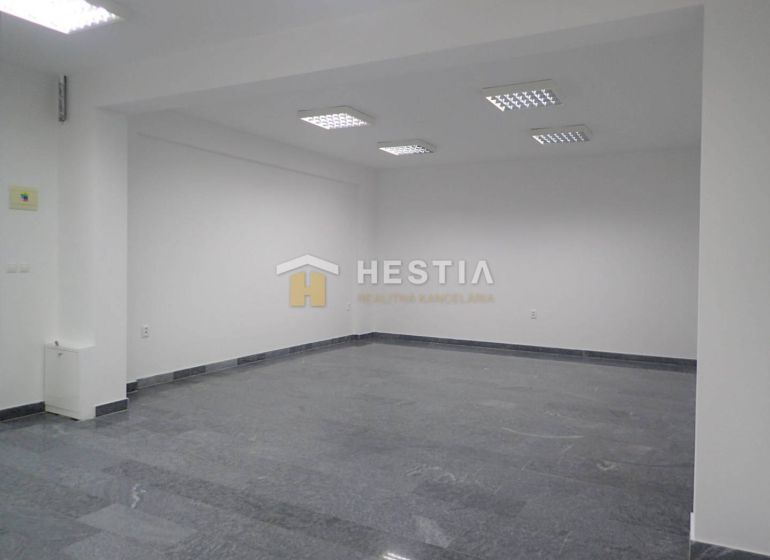 A spacious office with tiled flooring and lighting. Suitable for commercial land.