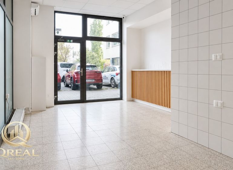 A bright room with large windows and tiled flooring, ideal for commercial spaces.