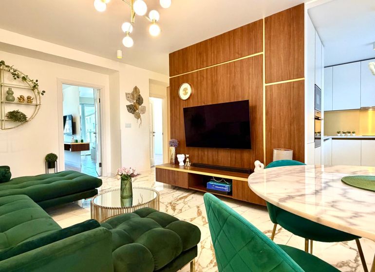 A living room in a 3-room apartment with a marble floor and green sofas.