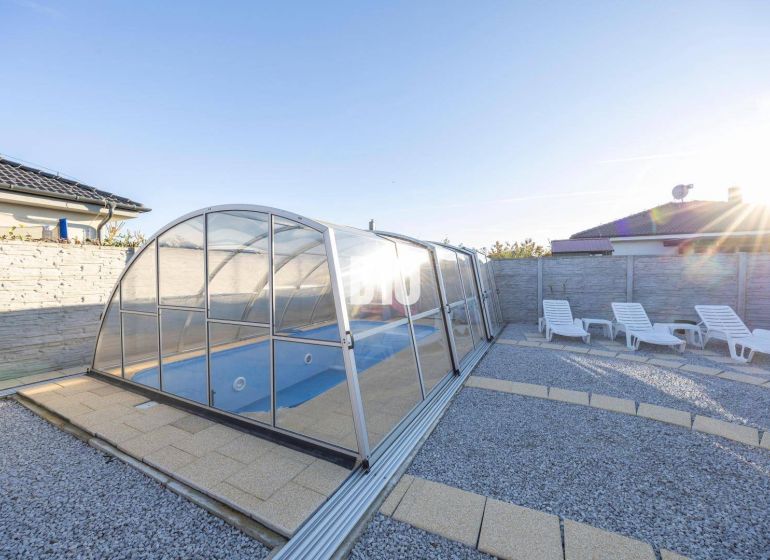 The garden of a family house in Most pri Bratislave with a swimming pool and loungers.