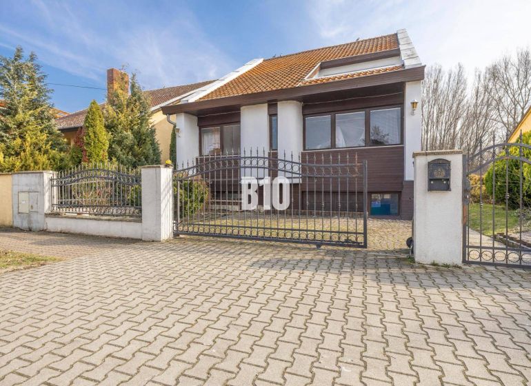 A family house on Dunajská Street in Hamuliakovo with a metal gate and a garden.