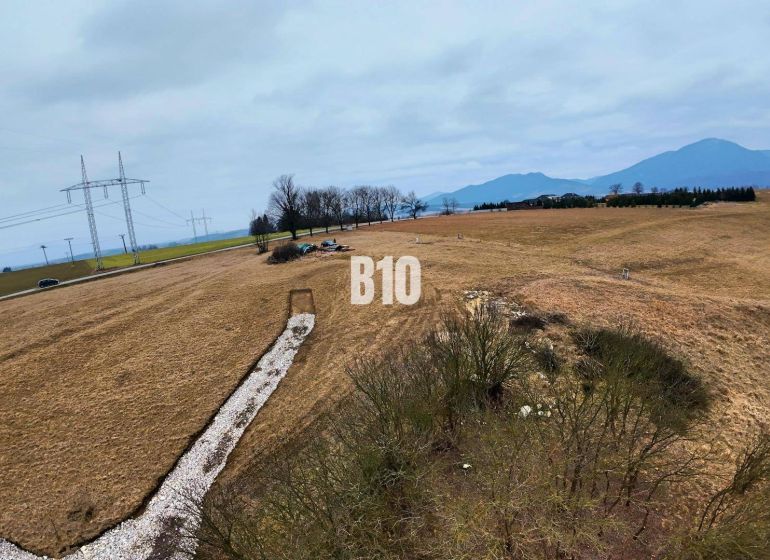 Hilly landscape in Laskár suitable for residential plots, with power lines in the background.