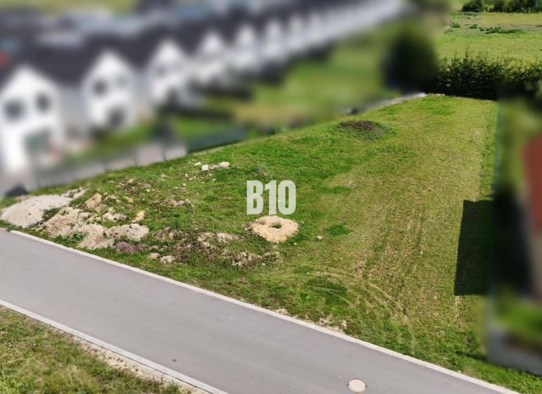 A plot suitable for living in Diakova with an access road and surrounding development.