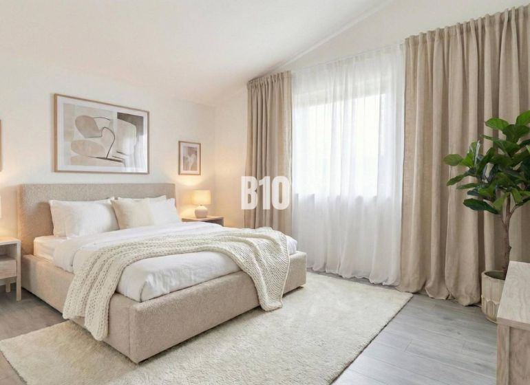 A bright bedroom with a large bed, curtains, and plants in a family house.