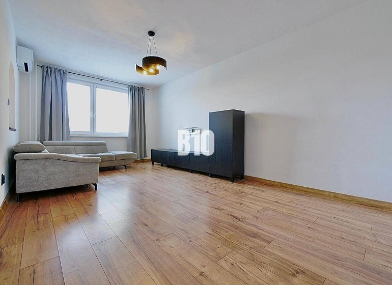 Living room in a 3-room apartment with a comfortable sofa and a wooden decor floor.