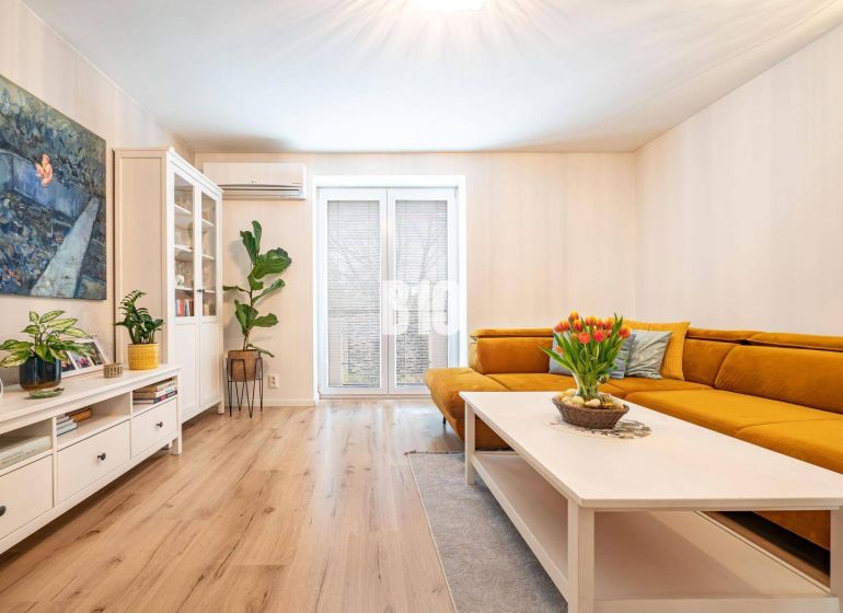 Living room in a 3-room apartment with a yellow sofa and a wooden decor floor.