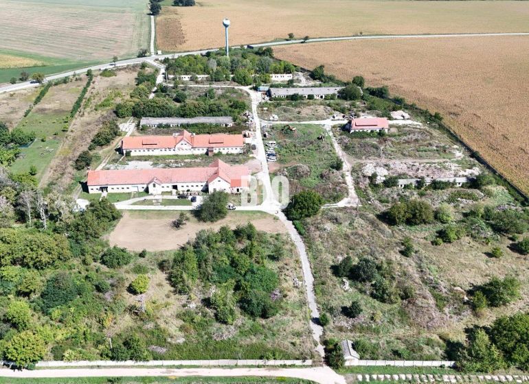 An area with buildings and nature surrounded by agricultural and forest lands in Levice.