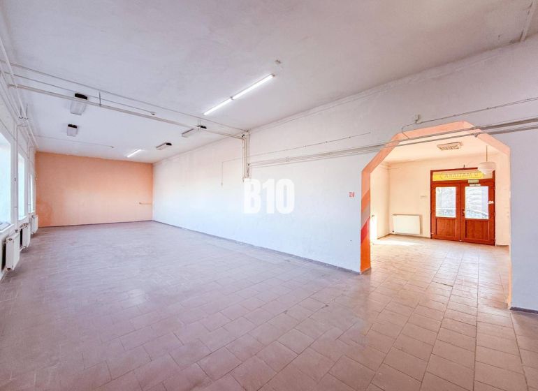 Spacious commercial premises with tiles and large windows, suitable for business.