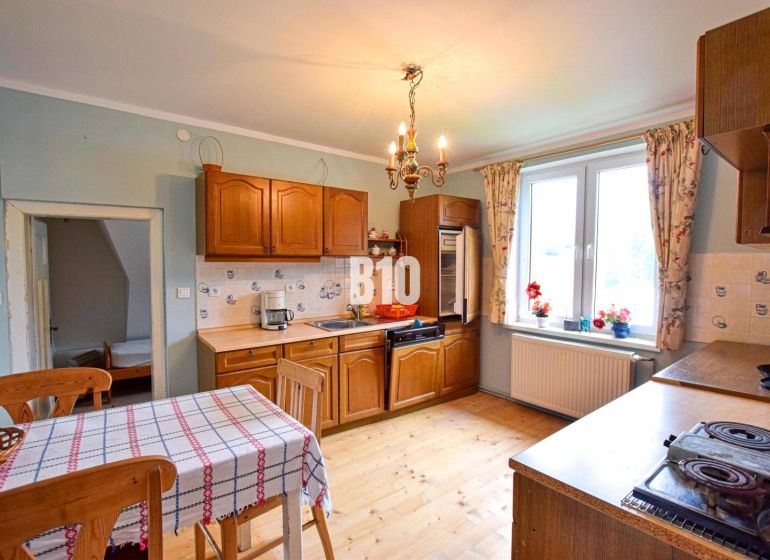 A kitchen in a family house with a wooden decor floor and wooden furniture.