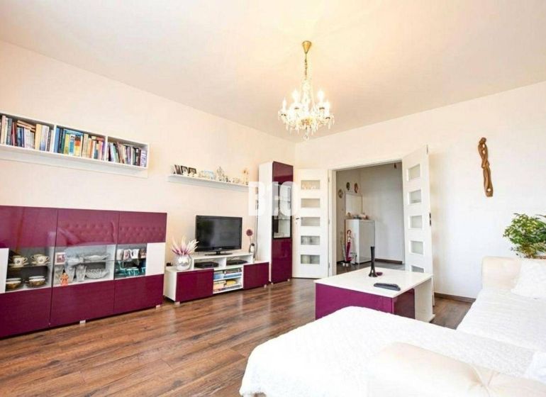 Living room in a 3-room apartment with a wooden decor floor and stylish furniture.