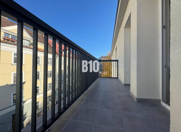 A balcony with a view of buildings in Žilina, suitable for a 2-room apartment.