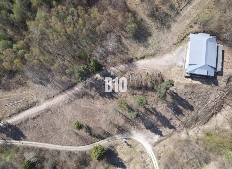 Aerial view of residential plots in Žilina surrounded by forest environment.