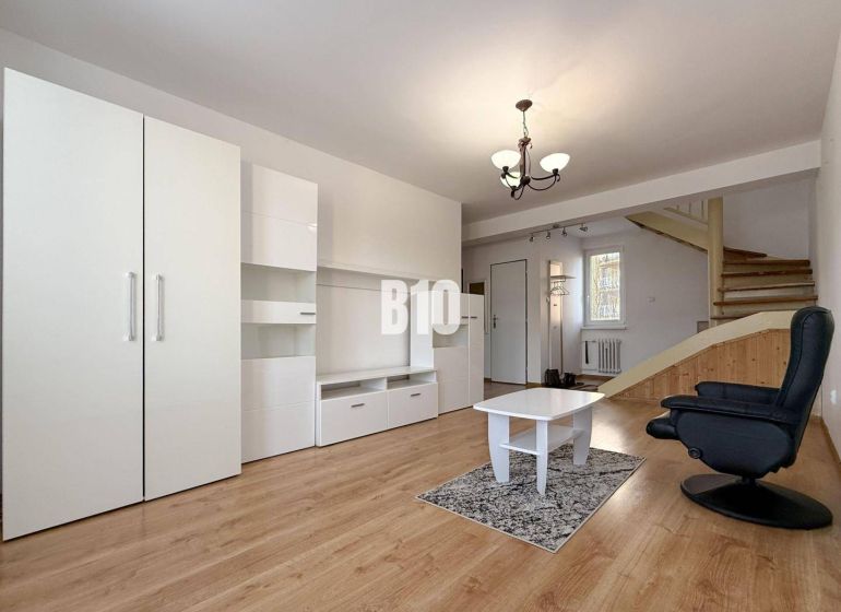 Living room in a holiday apartment with white furniture and a wooden decor floor.