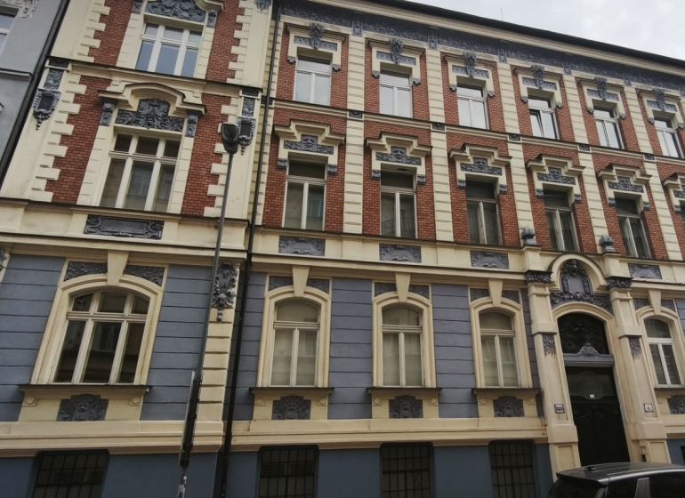 A historic building on Leškova Street in Bratislava with an advertisement for a real estate agency.