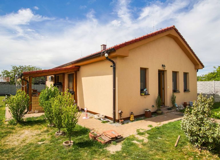 A family house in Andovce with a nicely landscaped garden and a brick walkway.