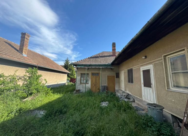 A family house in Bánov on Bánov Street with a grassy yard and a sloped roof.