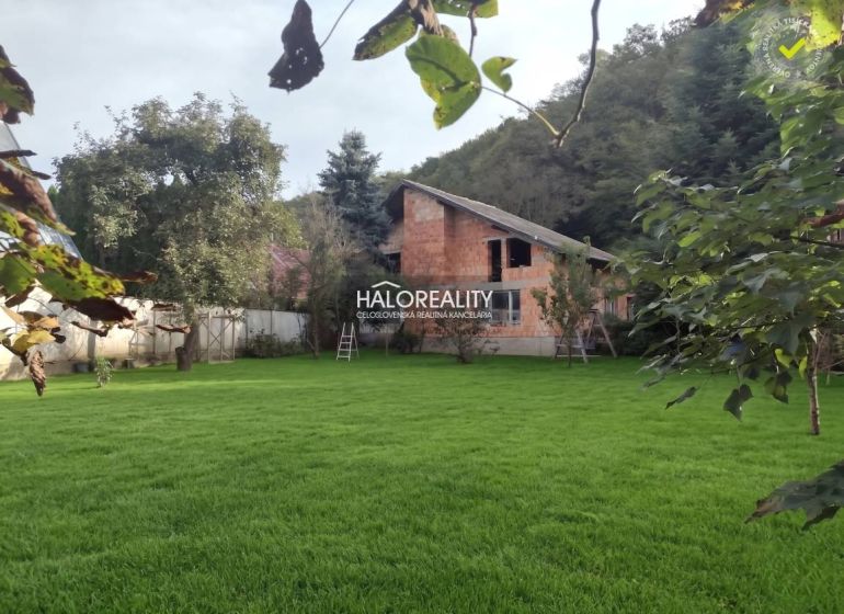 A family house in Poltár surrounded by a lawn and trees in a green environment.
