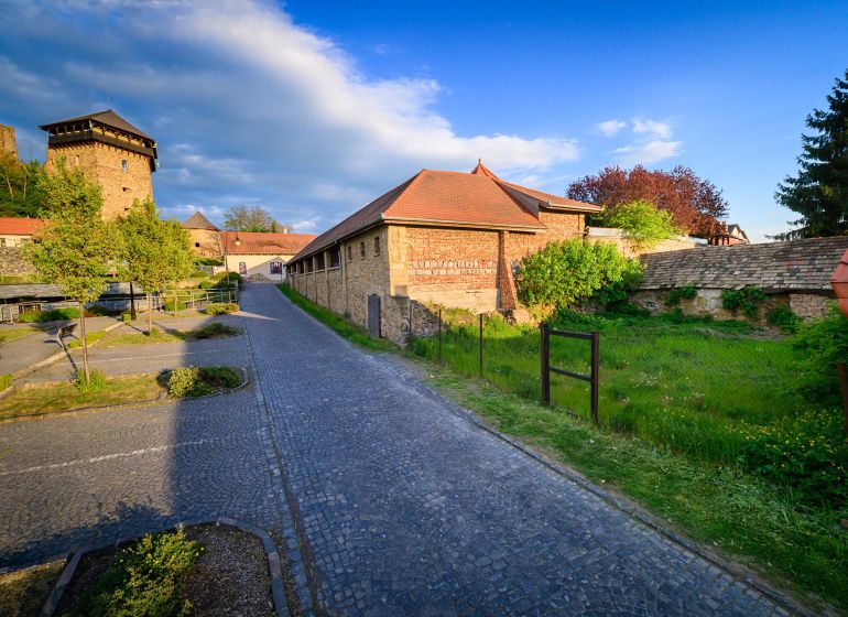 A stone pathway running alongside a historic building in the Grounds - commercial in Fiľakovo.
