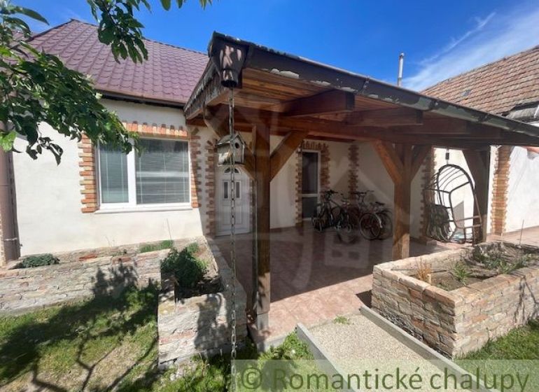 A family house in Palárikovo with a shelter, a swing, and bicycles in the yard.
