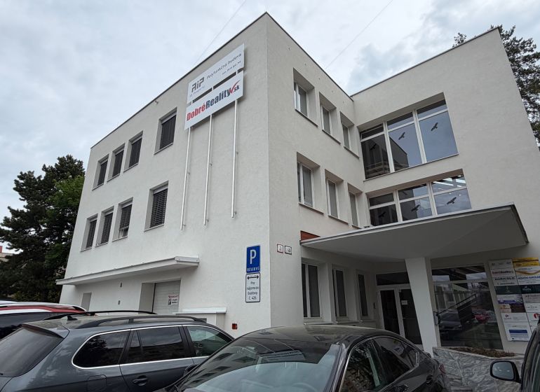 Office building on Dlhá Street in Prievidza with parked cars.