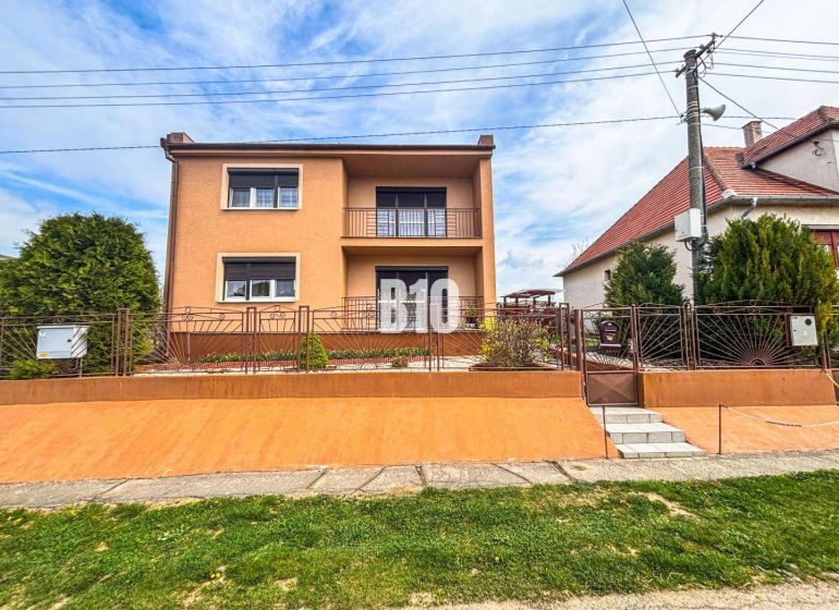 A family house in Lukáčovce with a garden and an elevated entrance surrounded by a fence.