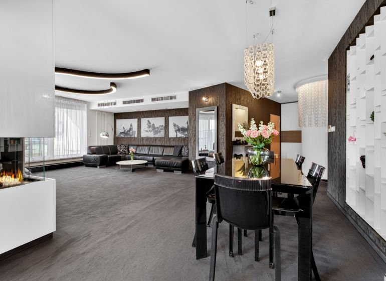 Living room with a sofa, dining table, and fireplace in a 4-room apartment.