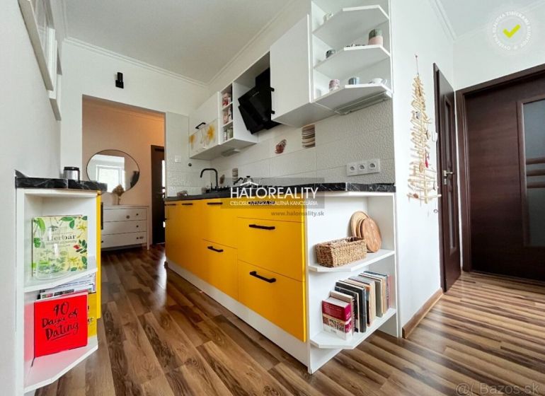 A kitchen with yellow cabinets and a wood-patterned floor in a 3-room apartment.