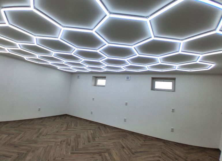 Commercial premises with a wooden decor floor and unique ceiling lighting.
