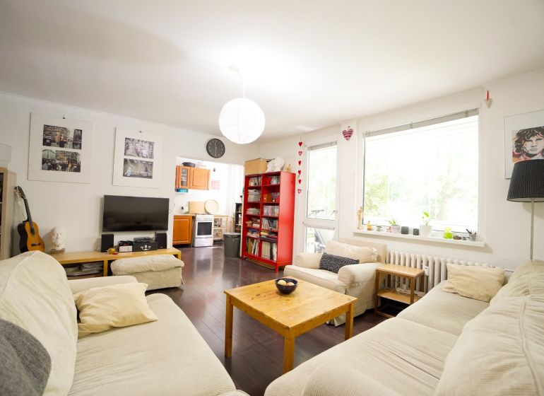 Living room of a 3-room apartment with comfortable sofas and a wooden decor floor.