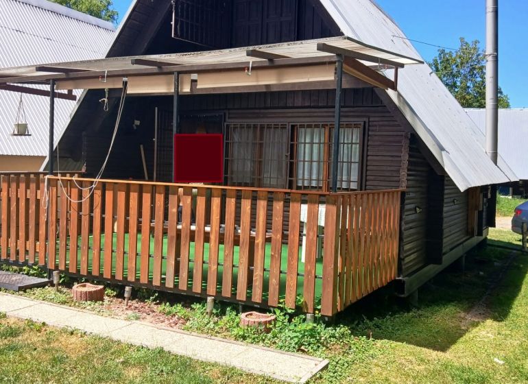 A cottage in Vinné with a wooden terrace and a small yard, surrounded by greenery.