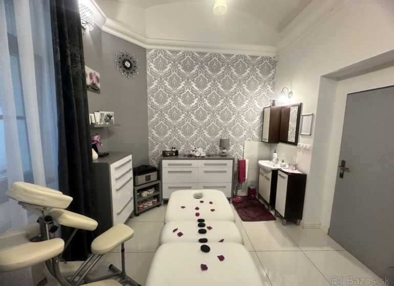 Massage room with a decorated wall, table, and lounger for relaxation treatments.