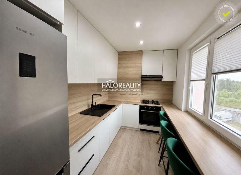 A kitchen in a 2-room apartment with a wooden decor floor and modern equipment.