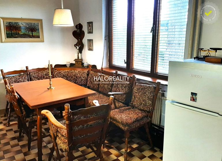 A dining room in a family house with a corner bench and checkered floor, decorations on the walls.