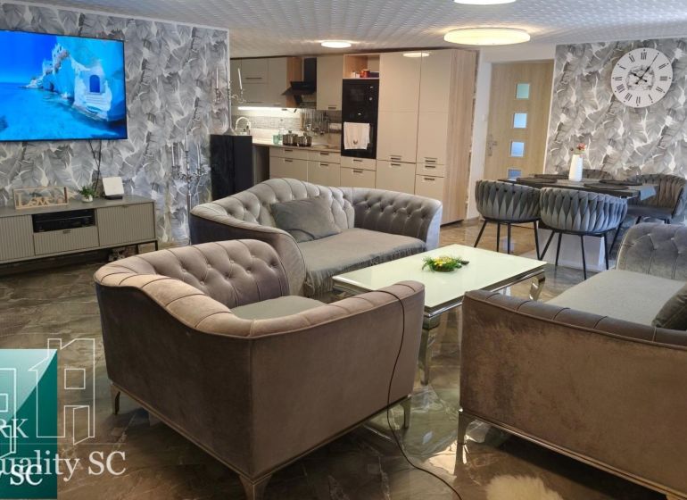 Living room in a family house with comfortable sofas, a TV, and stylish wall decor.