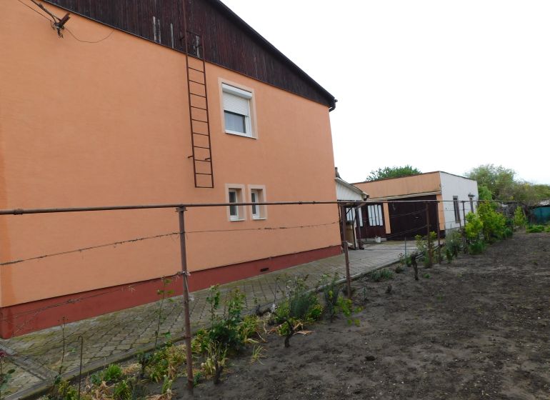 A family house in Dvory nad Žitavou with an orange facade and an adjacent garden.