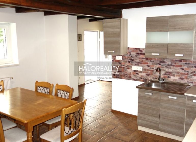 A kitchen in a family house with natural decor, brick cladding, and a wooden decor floor.