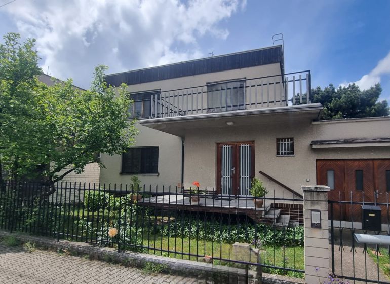 A family house in Leopoldov with a flat roof, a two-story terrace, and a green garden.
