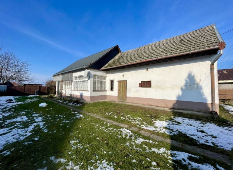 A family house on a plot in the village of Vrakúň, a snow-covered garden around the house.