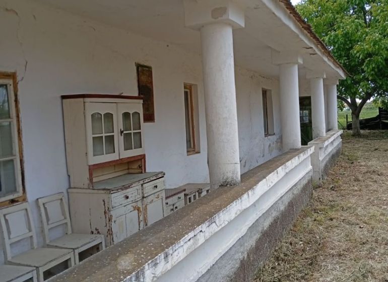 An older family house in Ňárad with a veranda and vintage furniture in front of the house.