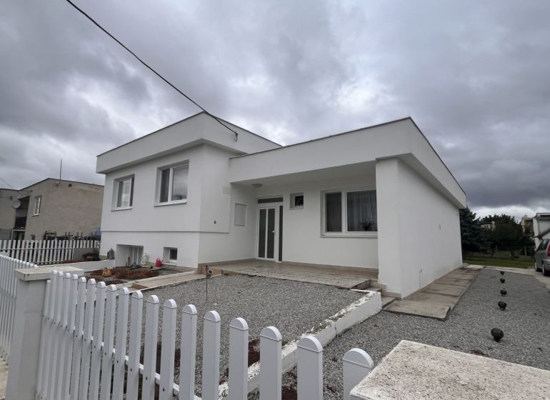 A family house in Trstice with a white facade and a gravel courtyard.