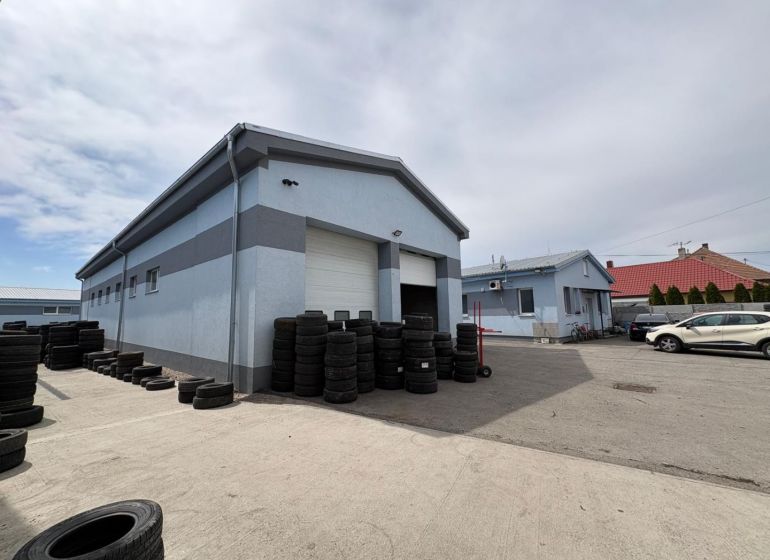 Warehouses and halls in Orechová Potôň with tires and cars in the yard.