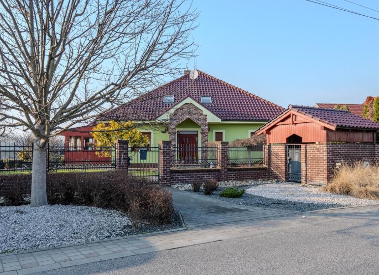 A family house in Dolný Bar with a red roof and green facade.