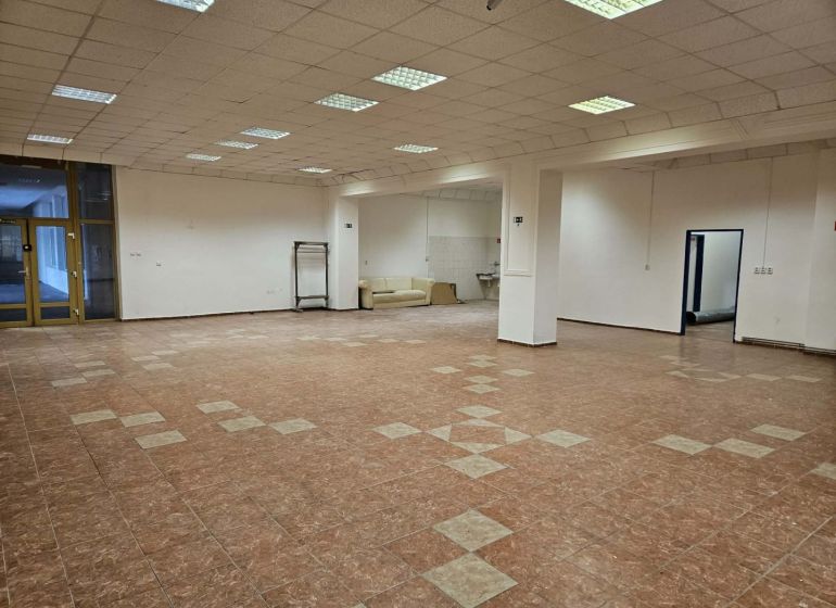 Spacious commercial spaces with a tile-patterned floor and white walls.