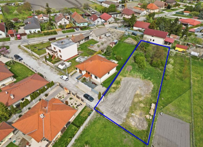 A plot for residential use in Horná Potôň surrounded by houses and greenery.