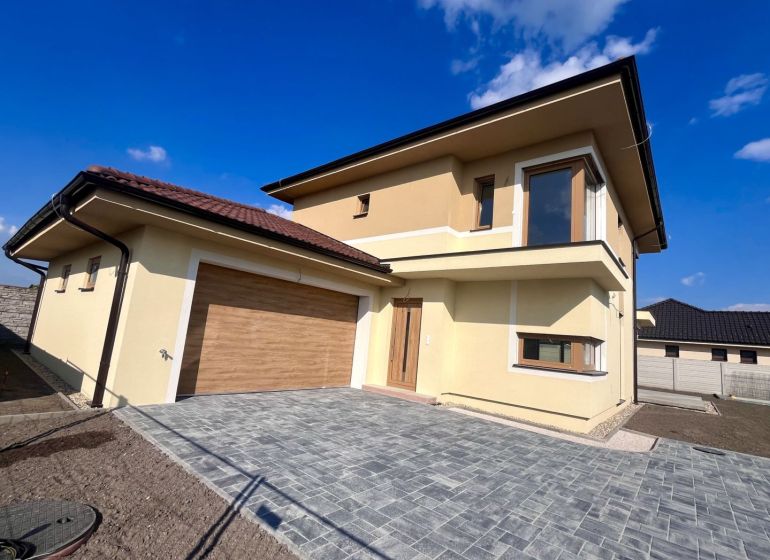 Family house on GARDENTOWN street in Dunajská Streda with garage doors and paving.