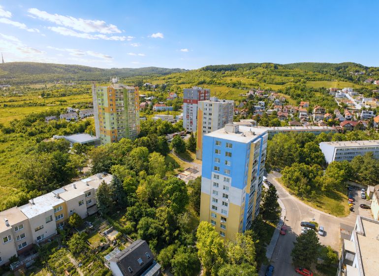 Aerial view of apartment buildings on Sadmelijská Street in Bratislava - Rača, surrounded by greenery.