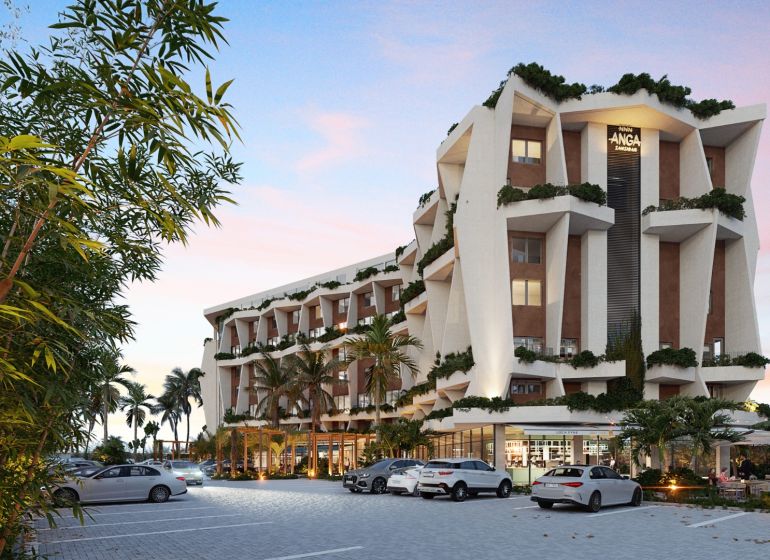 Residential complex in Paje, Unguja South, surrounded by greenery, parking in front of the building.