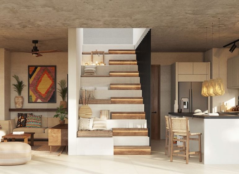 Living room of a two-room apartment with a kitchen, staircase, and plants.